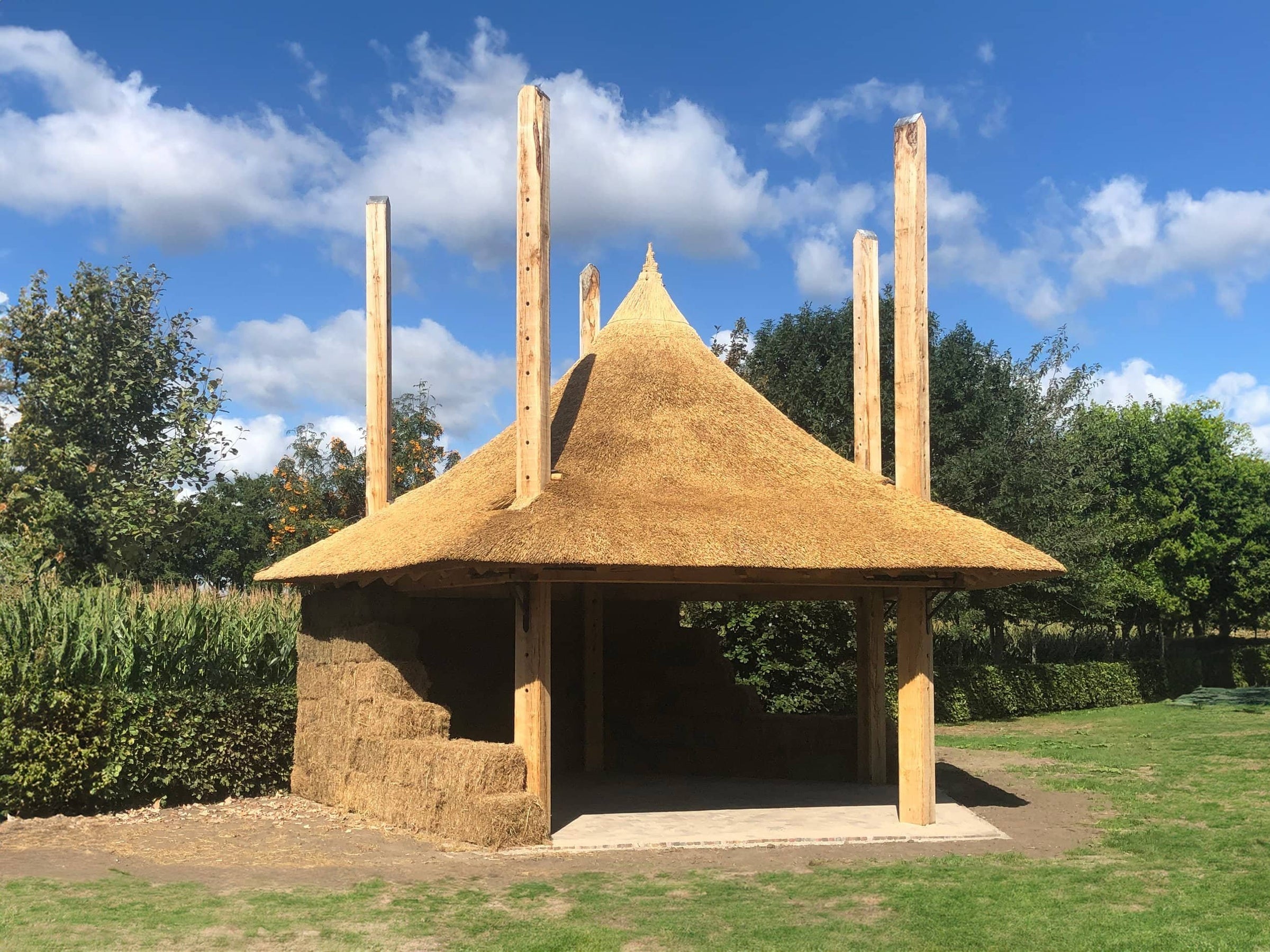 Voltooide hooiberg met een rieten dak en gevuld met hooi, gebouwd met een eikenhouten constructie.